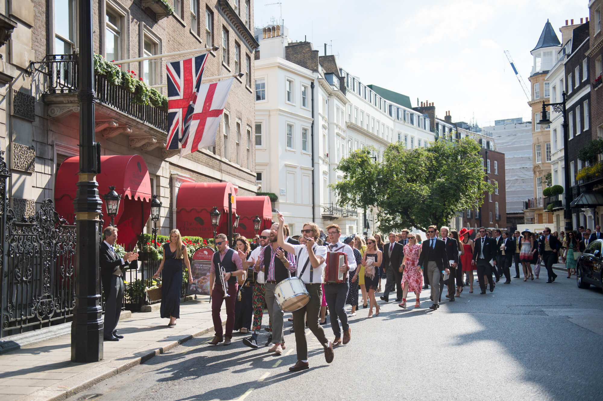 A live band leading the wedding party through the streets of Mayfair in London